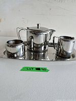 Front view of teapot, creamer, sugar bowl and tray
