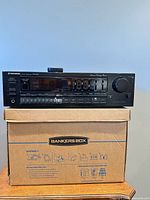 Front view of Pioneer SX-240 stereo receiver atop box