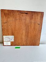 Back view of wood-mounted map showing hanging wire and information label