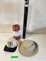 Group shot showing all four items: Tilley hat, signed baseball cap, rolled blanket, Scratch Map tube