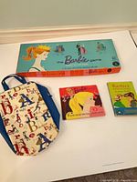 Overall lot showing board game box, two record sleeves, paperback book and tote bag