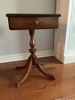 Full view of the mahogany side table showing drawer, pedestal, and legs
