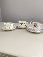 Three complete teacup and saucer sets side by side