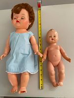 Both dolls side by side with tape measure, showing sizes, dress, missing toes