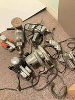 Group view of six corded power tools with cords visible
