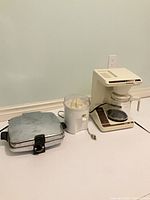 All three appliances side by side: sandwich press, coffee maker, juicer