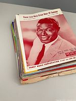 Stack of sheet music with Nat King Cole cover visible