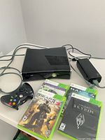 Console, controller, power brick, cables, games grouped