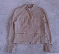 Front view of light beige suede jacket showing overall style, zipper closure, pockets, collar, sleeve length
