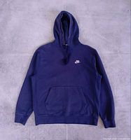 Front view of blue Nike pullover hoodie with kangaroo pocket and hood