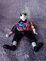 Front view of porcelain clown doll seated