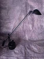 Full view of black counterbalance desk lamp showing overall form and adjustable arm