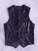 Front view of black leather vest showing buttons and pockets
