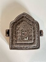 front view of ornate repoussé amulet case
