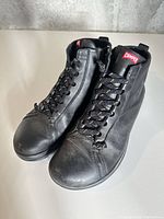 Front angle of both shoes showing laces, toe condition and Camper tongue logo