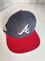 Front view showing navy crown, red brim, white A logo