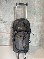 Front view showing telescopic handle, wheels, compartments, logos