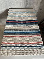 Full view of knit blanket folded on surface