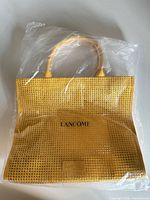 Front view of sealed yellow Lancôme tote bag