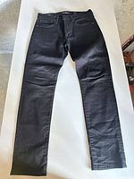 Full view of black slim jeans laid flat