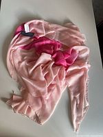 Full view of pink ombre scarf spread on surface