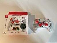 Controller beside original box showing design and packaging