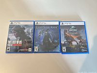 Front view of three PS5 game cases: The Last of Us Part II Remastered, Lost Soul Aside, Jurassic World Evolution 2