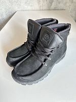 Oblique view of both boots showing lace system, toe and tongue logos