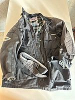 Full view of dark grey waxed cotton jacket with belt and pockets