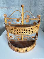 Front view showing two-tier half-round rattan cane shelf with scrollwork and finial