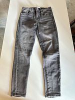 Full view of gray denim jeans laid flat