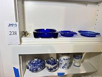 Top shelf showing three cobalt blue glass ashtrays