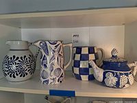 Front view of all four ceramic pieces on shelf