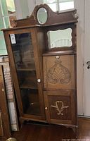 Front view showing entire secretary bookcase with glass door, mirrors, carvings