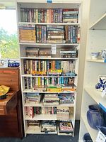 Full bookshelf packed with VHS tapes on five shelves