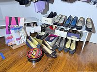 Shelves with multiple pairs of shoes, packaged hosiery and Kiwi polish tin