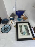 Group shot of all items including framed art, plate, bowl, multiple bird figurines, birdhouse and brass heart