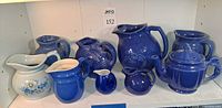 Front view of all eight ceramic pieces on shelf