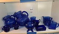 Group shot of all nine cobalt blue Hazel Atlas depression glass pieces on shelf
