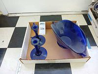 Overview of two cobalt blue candlestick holders and fan-shaped bowl in box