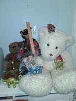 Group shot of all toys: three teddy bears, two sailor dolls bagged, four dinosaurs, small leopard plush