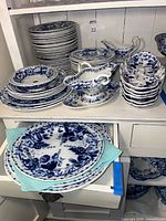 Full set on shelving showing multiple stacks of plates, bowls and two gravy boats