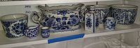 All seven Delft blue porcelain pieces on shelf
