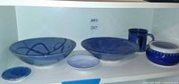 Shelf view of all six blue and white stoneware pieces