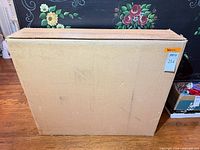 Sealed cardboard shipping box containing the wreath