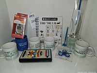 Group shot of all items including five mugs, pedometer, activity book, test board, fidget spinner, back scratcher