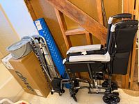 Group shot of boxed tub bench, folded walker, bedside commode, foam roller, folded wheelchair