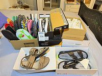Assorted shoes in boxes including sandals, white sneakers and flip-flops
