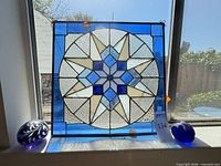 Full view of stained glass panel and both paperweights on windowsill