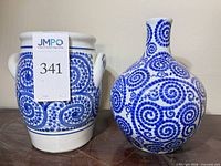 Front view of both blue and white porcelain pieces showing spiral pattern and form